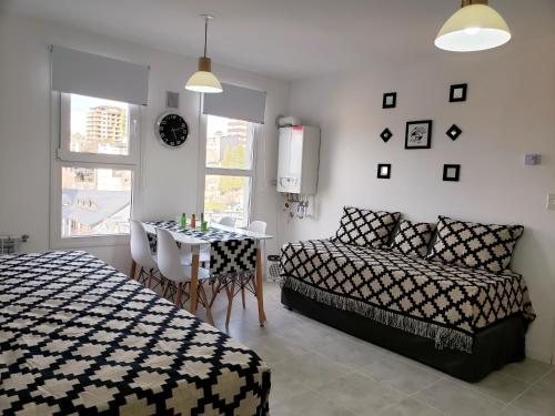圣卡洛斯-德巴里洛切Bariloche Modern Apartment的卧室配有1张床、1张桌子和1把椅子