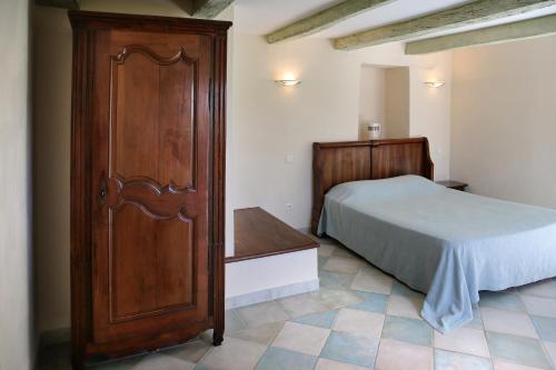 ParnacEARL DOMAINES DELMAS的一间卧室配有一张床和一个木制橱柜
