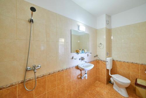 帕莫瑞Peneka Hotel的带淋浴、卫生间和盥洗盆的浴室