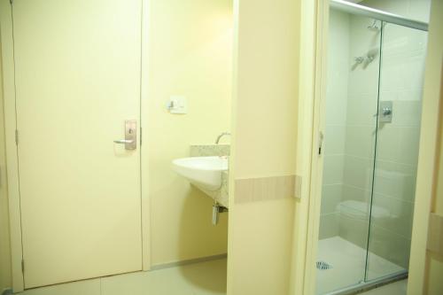 因佩拉特里斯Stay Inn Hotel的一间带水槽和玻璃淋浴的浴室