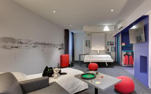 南特南特中心宜必思风格酒店的一间卧室配有一张床、一张桌子和一张沙发