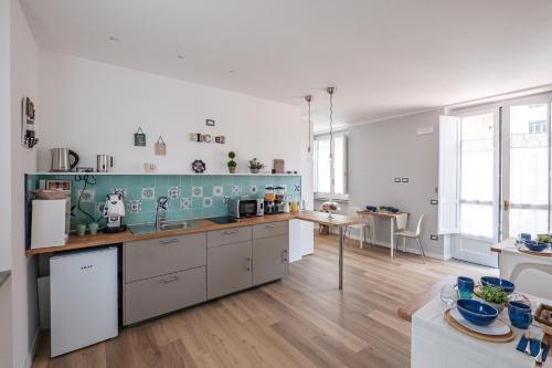 卡瓦德蒂雷尼B&B Terza Luna的厨房拥有白色的墙壁和蓝色的瓷砖