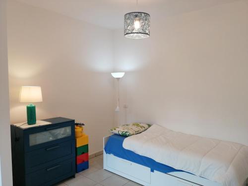 弗雷杰内monolocale Fregene via Agropoli的一间卧室配有床、梳妆台和台灯。
