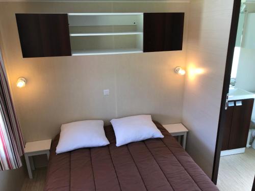 Jau-Dignac-et-LoiracLE MEDOC AUX 4 VENTS的一间卧室配有一张带两个白色枕头的床