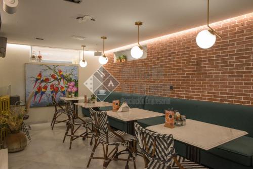 桑坦德拉斯布里萨斯精品酒店的一间带桌椅的餐厅以及砖墙