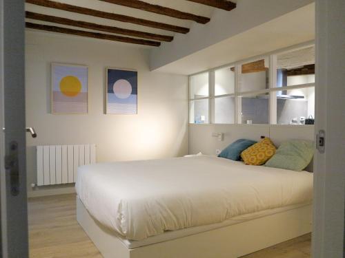 潘普洛纳El Oasis de la Estafeta的卧室设有一张带窗户的白色大床