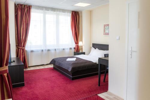 华沙SCSK祖拉威亚公寓的一间卧室配有一张床、一张书桌和一个窗户。