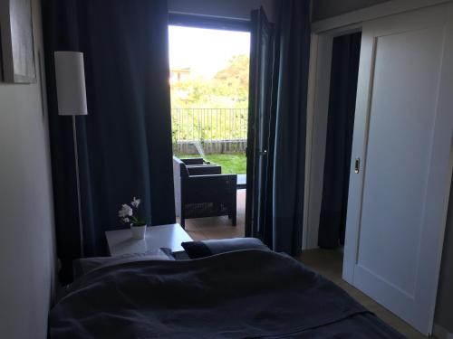 济夫努夫Apartament Fala Gardenia Seaside的一间卧室设有两张床和一个带椅子的窗户。