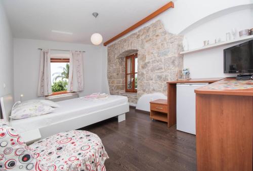 图彻皮Oldhouse Tučepi的卧室配有白色的床和石墙
