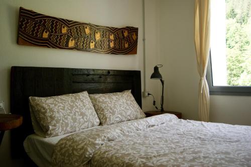 CalizzanoUn coccodrillo a FrAsSiNo的卧室配有一张床,墙上挂着一幅画