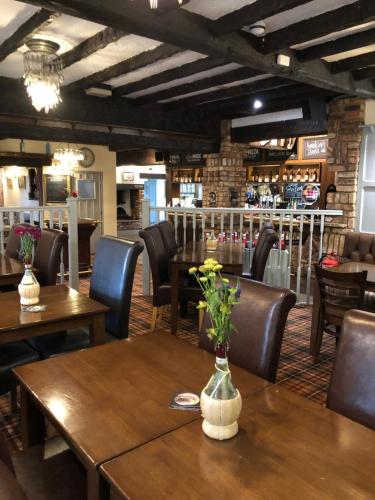 SnaithThe Brewers Arms的餐厅设有木桌和鲜花椅子