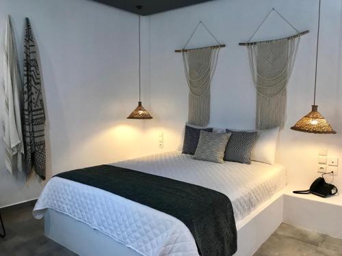 LakkíonAELLIA HOTEL & SUITES LEROS的卧室配有带两盏灯的白色床