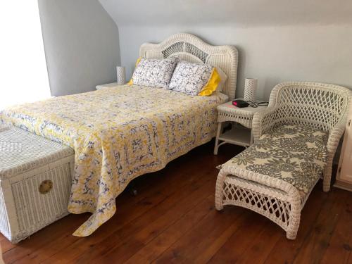 贝菲尔德Lucy's Place的一间卧室配有一张床和两张藤椅