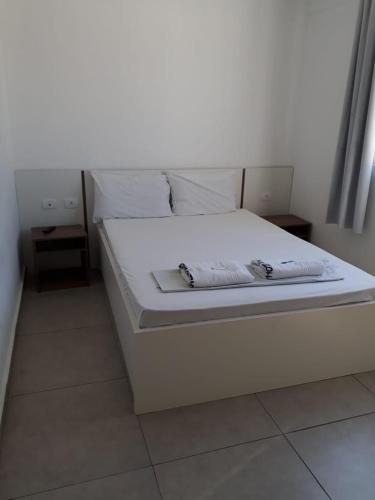 库里提巴Hotel Lisboa的白色的床、白色床单和枕头
