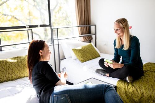 奥克兰基督教青年会旅馆的两个坐在沙发上的女人在客厅里说话