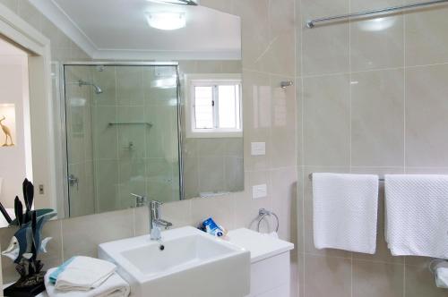 莫里莫科Mollymook Beach Waterfront的白色的浴室设有水槽和淋浴。