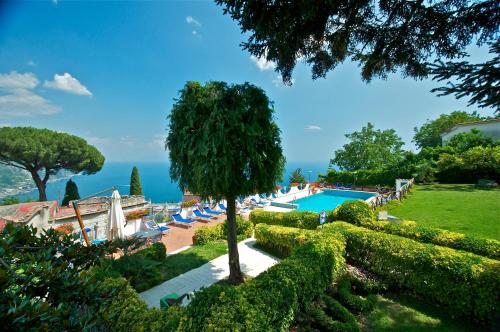 拉维罗Villa Casale Ravello Residence的享有带椅子和树的游泳池的景色