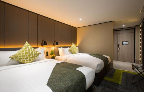 希灵登Aerotel London Heathrow, Terminal 2 & Terminal 3的配有白色和绿色枕头的酒店客房的两张床