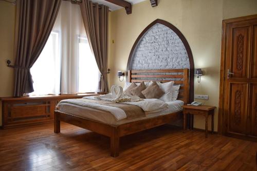布哈拉马力卡布哈拉酒店的一间卧室配有一张大床和木制床头板