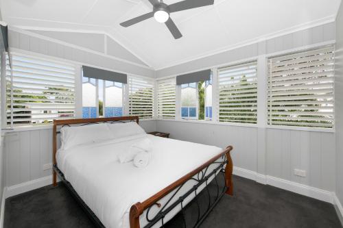 汤斯维尔美丽的昆士兰度假屋的一间卧室配有一张带白色床单和窗户的床。
