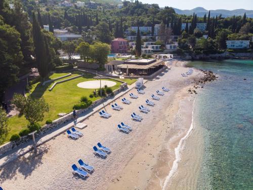 米利尼Maistra Select Astarea Hotel的海滩空中美景,配有椅子和水