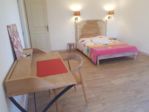 Saint-Bauzille-de-PutoisMas des Ballats的卧室配有1张床、1张桌子和1把椅子