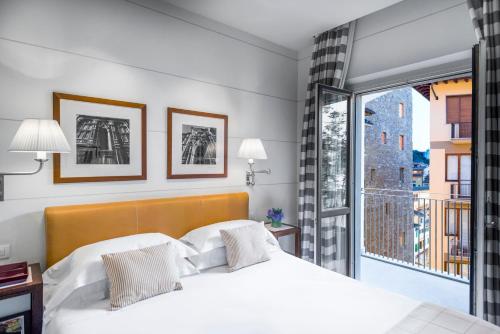 佛罗伦萨艺术画廊酒店 - 朗伽诺酒店集团的一间带白色床的卧室和一个阳台