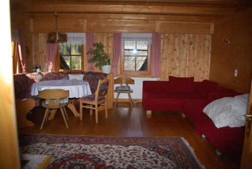 SchöderBauernhof Hatzlhof的客厅配有红色的沙发和桌子