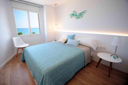 卡内·德·玛尔Apartamento frente al mar的一间卧室配有一张床、一张桌子和一个窗户。