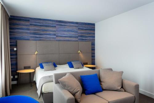 让布卢3把钥匙酒店的一间卧室配有一张带蓝色枕头的床和一张沙发。
