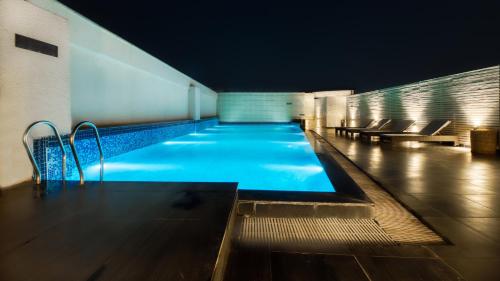 古尔冈古尔冈中央华美达酒店的一座建筑物的游泳池