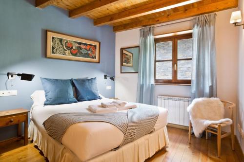 GessaLuderna - Apartamento Orri A4的一间卧室配有一张蓝色墙壁的床和一扇窗户