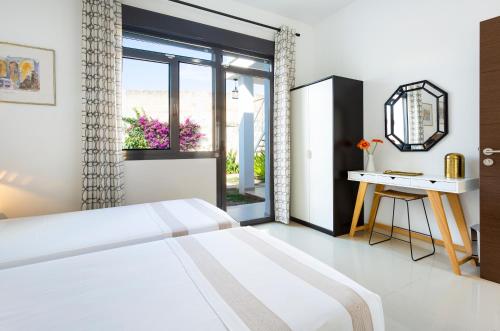 马略卡岛帕尔马Casa en Son Espanyolet的一间卧室配有一张床、一张书桌和一个窗户。