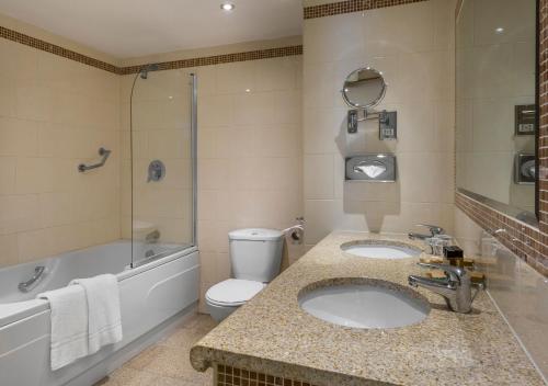 都柏林伯宁顿休闲中心酒店的一间带两个盥洗盆、浴缸和卫生间的浴室
