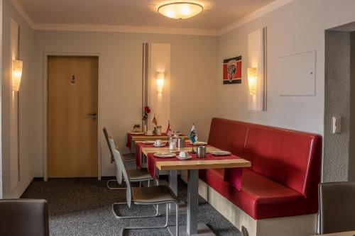 因戈尔施塔特Pension Torkel-Stube的餐厅设有长桌和红色椅子