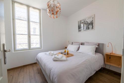 圣艾米隆Le 25, appartement moderne au cœur de Saint-Emilion的卧室配有一张白色大床,上面有托盘