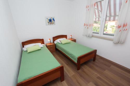罗维尼迪娜公寓的一间卧室设有两张床和窗户。