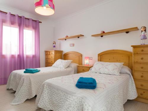 穆罗Villa marimar的卧室内的两张床,配有紫色窗帘