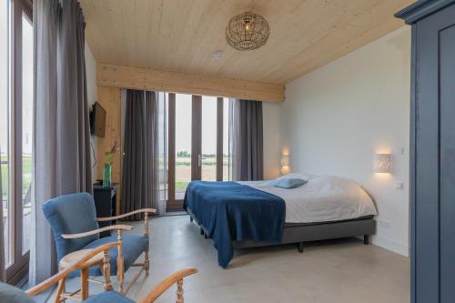 希勒霍姆De Groene Bollenschuur的一间卧室设有一张床和一个大窗户