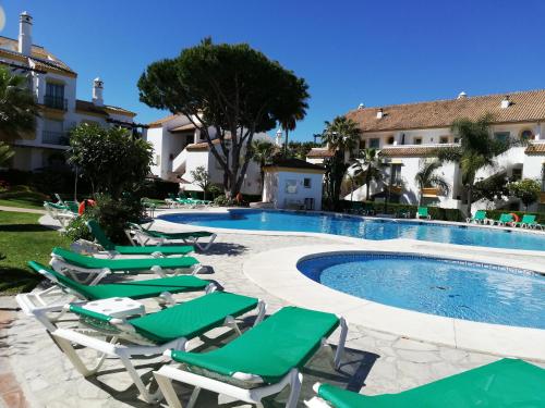 马贝拉Carib Playa Marbella apartments的一组躺椅和一个游泳池