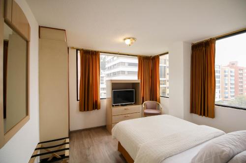 基多斯坦福套房酒店的酒店客房,配有床和电视