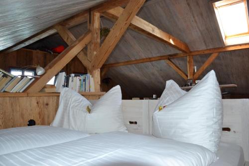 阿特湖畔努斯多夫达斯格拉芬古特酒店的一间卧室配有带白色枕头的床