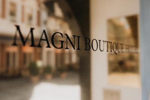 布伦瑞克Magni Boutique Hotel的读商人精品店的窗口上的标志