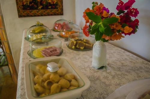 卡诺格布拉达Pousada Morada do Sol的一张桌子,上面放着一盘食物和花瓶