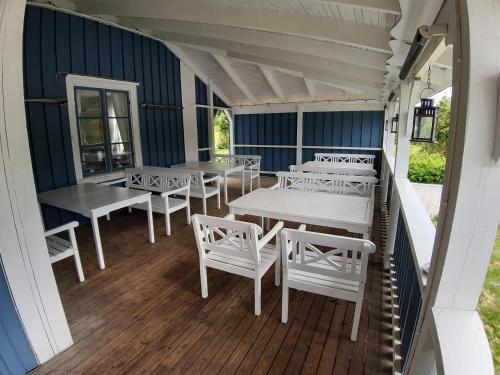 希塞里贝克Wärdshuset Klarälvdalen的带顶棚的门廊配有白色的桌子和白色的椅子