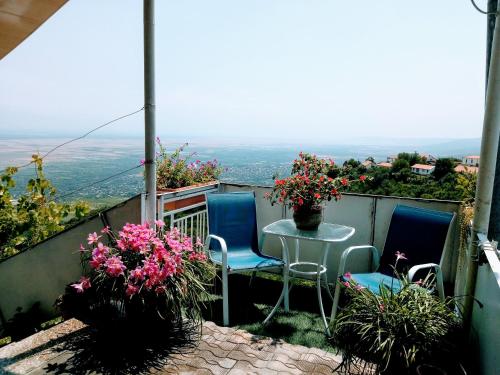 西格纳吉阿布拉米其旅馆的阳台配有桌椅和鲜花。
