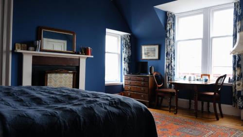 奈恩Denson Villa的卧室拥有蓝色的墙壁,配有桌子和床