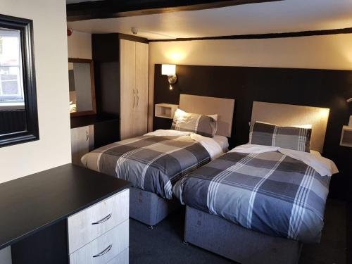 牛津The Old Black Horse Inn的一间卧室配有两张床和一张书桌