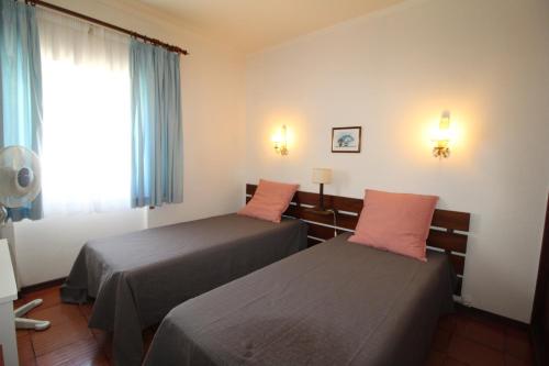 波尔蒂芒ApartamentoSolPraia - BeloHorizonte的酒店客房设有两张床和窗户。