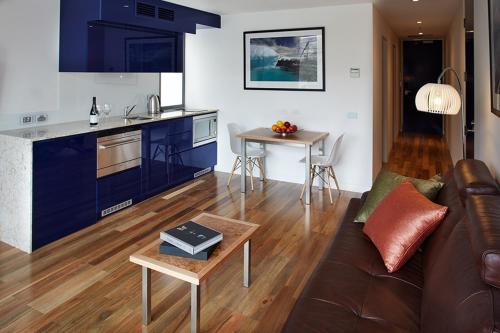 霍巴特萨拉曼卡码头酒店的厨房以及带沙发和桌子的客厅。